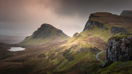 Weather at The Quiraing on Isle of Skye, Scotland. Mist, clouds and sunlight over green hills create painterly landscape scenery.
