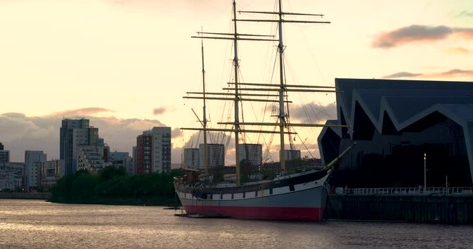 Glasgow, Scotland, UK - May 20 2022 Glasgow Tall ship on river clyde next to transport museum at golden hour sunset