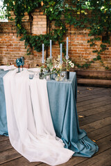 Stylish wedding table decoration and table setting. Blue tablecloth. Outdoor wedding party. Vintage 