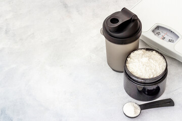 Fitness and gym diet food. Jar with whey protein and scales