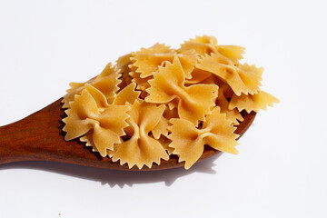 Uncooked bow tie pasta on white background.