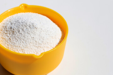 Detergent powder with measuring spoon for clothes washing. Laundry concept.