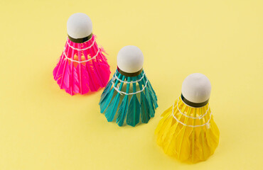 Bright shuttlecocks for badminton on a yellow background. Summer background.