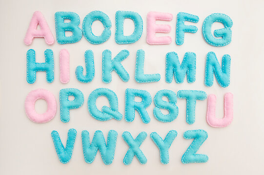 Full Alphabet In Capital Letters Made From Stuffed Felt On Wooden Floor Background. Toy And Implement For Preschool And Primary School Kids Learn To Read. Montessori Colors.