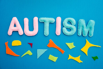 Autism awareness concept with puzzle and word autism on blue background.