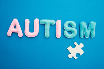 Autism awareness concept with puzzle and word autism on blue background.