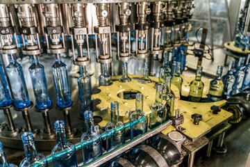 Beverage factory. Conveyor line with bottles for alcohol or water. Bottle cleaning filling and capping machine