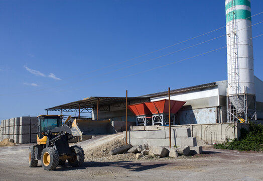 Tractor in dry aggregate warehouse for concrete block production