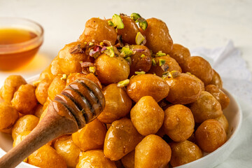 Sweet donuts in the form of balls. Arabic sweets luqaimat or lokma close-up.