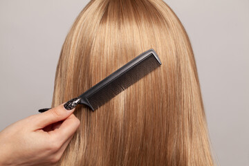 Closeup of woman with straight hair combing her hair