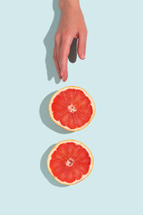 Fresh slices of grapefruits on turquoise background. Minimal food creative concept on turquoise pastel background