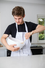 A Teenage Boy Cooking In A Kitchen