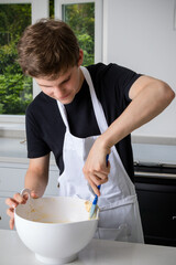 A Teenage Boy Cooking In A Kitchen
