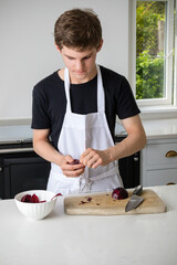 A Teenage Boy Cooking In A Kitchen