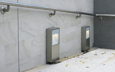 Outdoor walkway light lamp with steel handrail installed on wall.