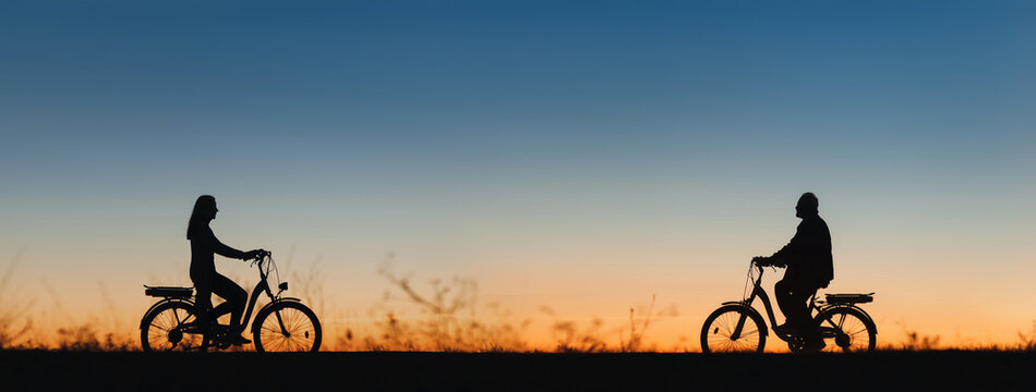An elderly man, a pensioner and a girl on electric bikes ride towards each other against the backdrop of the sunset sky. Silhouettes of people in profile. Active retirement, travel and sports.