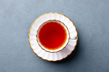 Tea in white cup. Grey background. Top view.