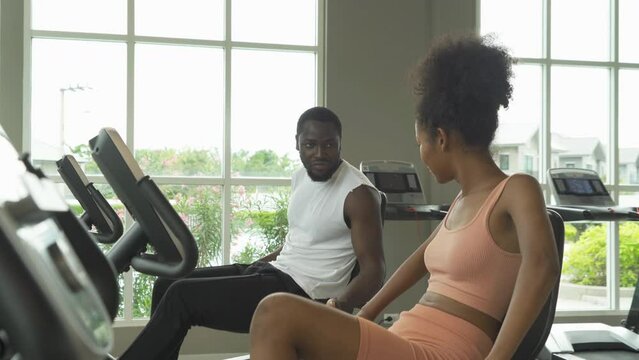 Black African american healthy couple, people, using fitness equipment, doing exercise, working out, and training in gym or fitness center in sport club. Recreation. Lifestyle activity people.