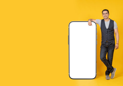 A man with a big phone. Place for the inscription on the phone monitor. A smartphone with an empty white screen. The man holds a large smartphone. A person shows a screen with a place for the inscript