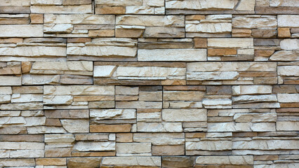 Closeup outdoor wall made of wild stone in beige color.