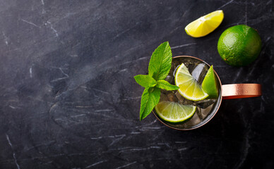 Moscow Mule cocktail in copper mug with fresh mint, lime. Dark marble background. Copy space. Top...