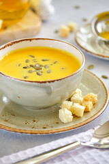 Tasty and healthy dietary food. Pumpkin soup cream on a gray background