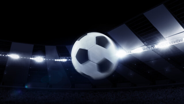 Flight of soccer football ball through dark evening stadium with spotlights. Concept of sport, art, energy, power