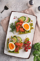 Savory waffles. Breakfast green waffles wild garlic or spinach with egg, tomato, salmon on plate for breakfast on grey concrete table background. Light dinner, lunch or breakfast. Top view. Mock up.