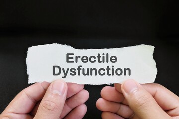 Erectile dysfunction diagnosis and anxiety concept. Male hand holding paper with written word text...