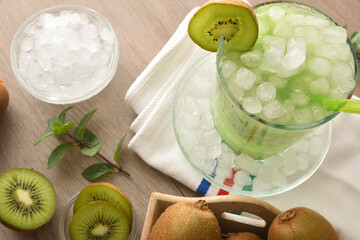 Detail of glass of kiwi juice with ice on table