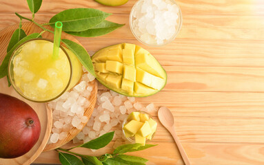 Glass with mango juice with ice on wooden table background