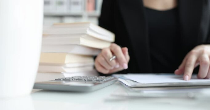 Businesswoman or accountant holding a pen working on calculator to calculate