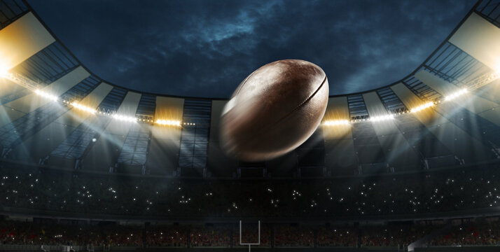 Flight of american football ball through dark evening stadium with spotlights. Concept of sport, art, energy, power