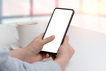 mockup cellphone. Mockup image of woman holding black mobile phone with blank screen with coffee cup on modern cafe. Closeup of woman hand holding smartphone