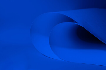 Abstract colored background, created with curved blue paper sheets. Curved lines and shapes and soft vivid colors.