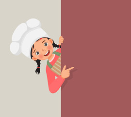 cute little girl in chef hat and apron peeking from board pointing finger to empty banner for copy space