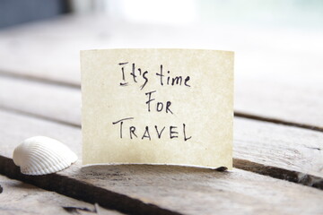 It's travel time. Paper card with an inscription. Summer Vacations idea.
