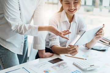 Fototapeta premium Negotiation, Analysis, Discussion, Portrait of an Asian women economist and marketer using tablet computer to plan investments and financial to prevent risks and losses for the company