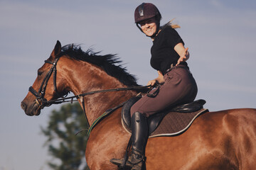 Uśmiechnięta dziewczyna jeździec konny na koniu na letnim polu  - obrazy, fototapety, plakaty