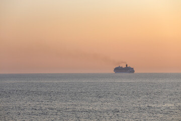 Passenger ship crossing the sea at sunset