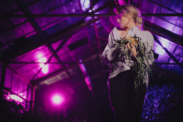 Dziewczyna w koszuli z bukietem kwiatów w opuszczonej szklarni - obrazy, fototapety, plakaty