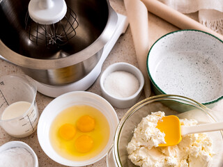 Ingredients for making cheesecake: eggs, cheese, sugar, dairy cream. Home cooking during the quarantine