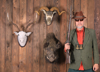 portrait of a hunter with a gun and trophies