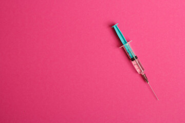 Medical syringe on a pink background. A syringe for injection. The concept of health and beauty