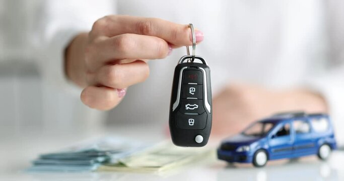Car dealer hands over car alarm key closeup