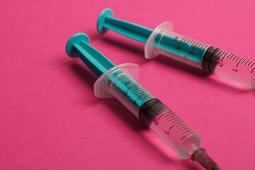 Medical syringe on a pink background. A syringe for injection. The concept of health and beauty