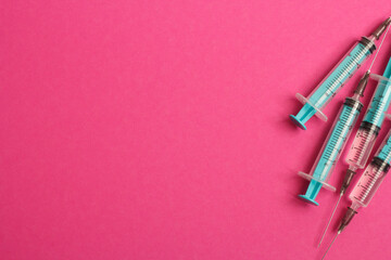 Medical syringe on a pink background. A syringe for injection. The concept of health and beauty