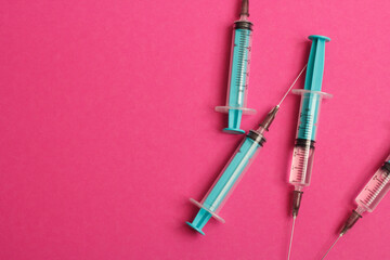 Fototapeta premium Medical syringe on a pink background. A syringe for injection. The concept of health and beauty
