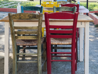 Fototapeta na wymiar Empty tavern outdoors seating area with wooden chairs and tables in Greece.