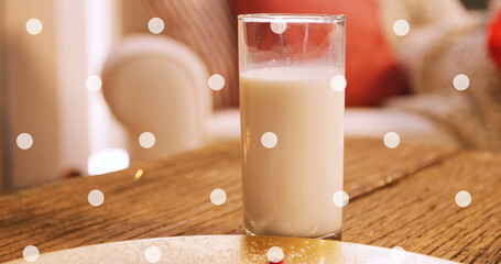 Image of white spots over milk and cookies at christmas